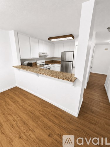 A kitchen with white cabinets and a granite countertop.