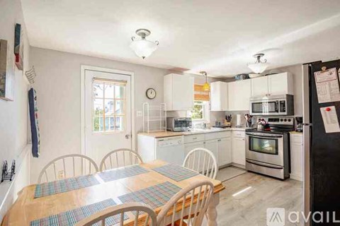 A kitchen with a table and chairs in front of it.