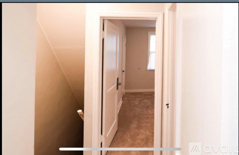 A hallway with a door on the left and a door on the right.