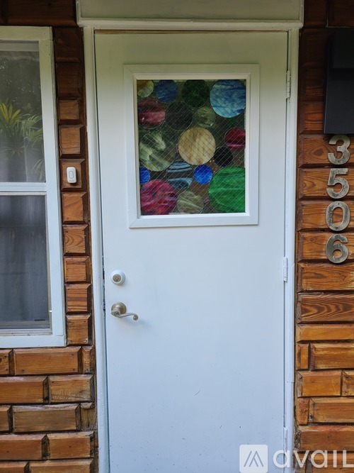 A white door with a glass window and a number 350 on the wall.
