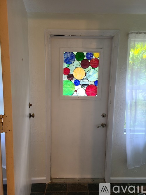 A white door with a stained glass window in the middle.