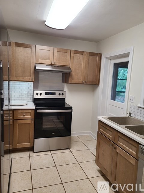A kitchen with wooden cabinets and a stainless steel oven.