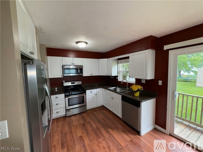 A kitchen with white cabinets and a black countertop.