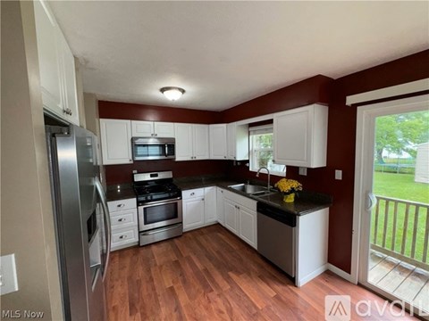 A kitchen with white cabinets and a black countertop.