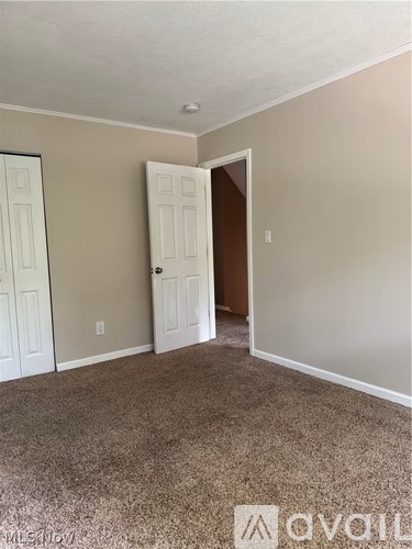 A room with a carpeted floor and two doors.