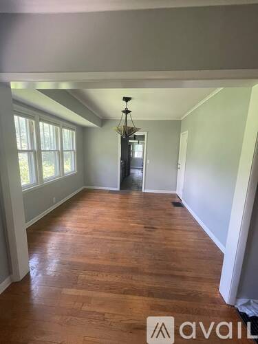 A room with wooden floors and a chandelier.