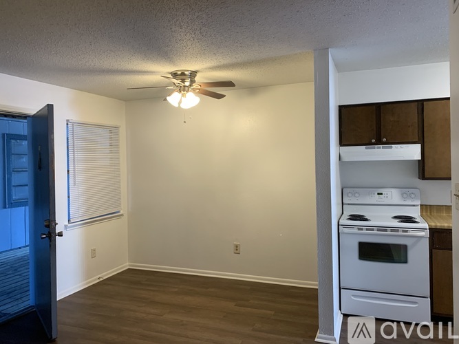 A kitchen with a stove and a fan on the ceiling.