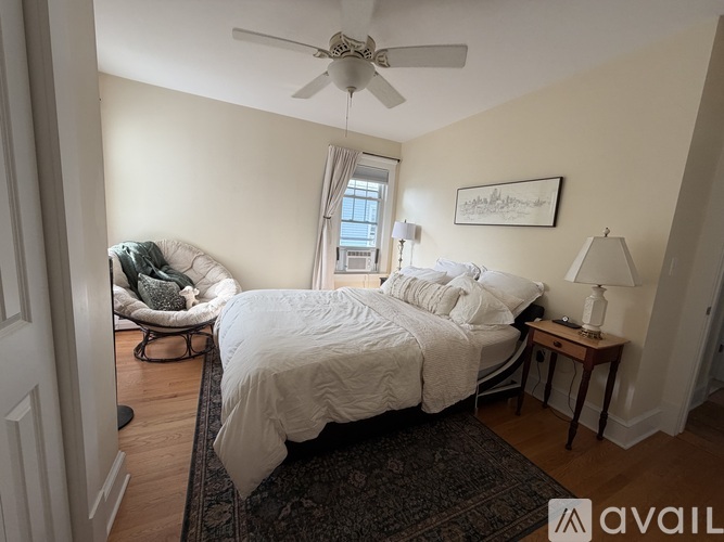 A bedroom with a large bed and a ceiling fan.