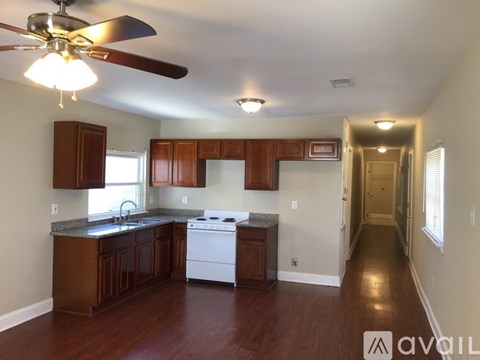 A kitchen with wooden cabinets and a white stove top oven.
