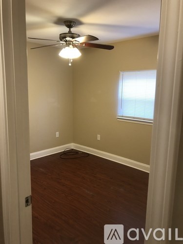 A room with a ceiling fan and a window.