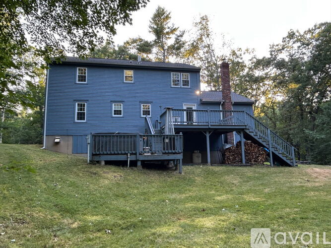 A blue house with a chimney and a porch.