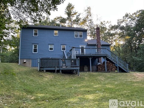 A blue house with a chimney and a porch.