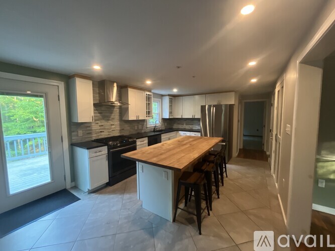 A modern kitchen with a wooden island and bar stools.