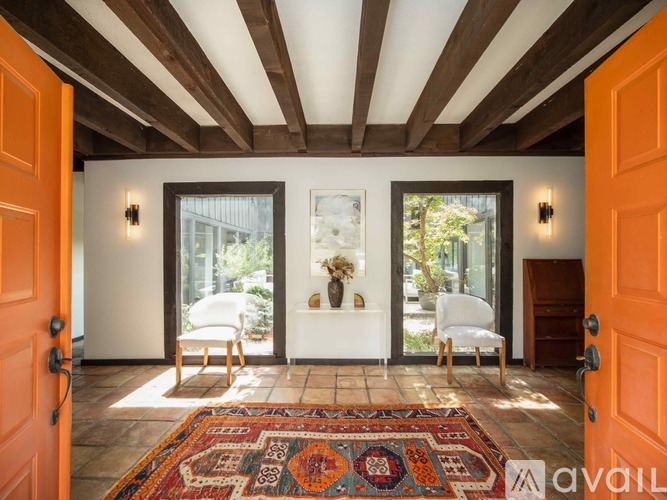 A room with a wooden ceiling and a rug on the floor.
