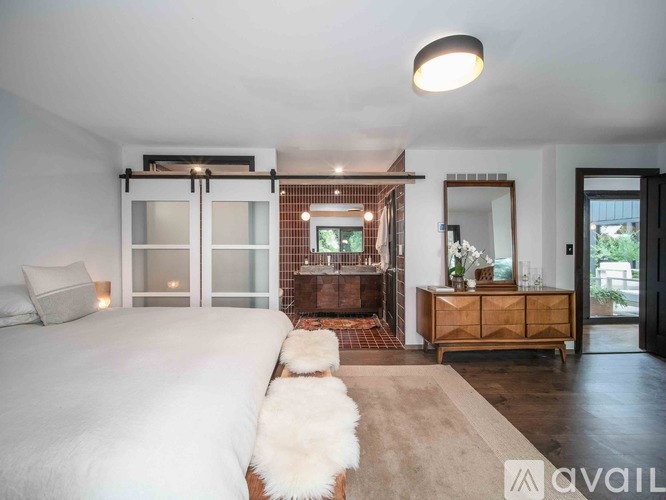 A bedroom with a large bed and a mirror on the wall.