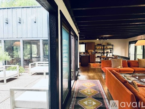 A living room with a couch and a rug in front of a glass door.