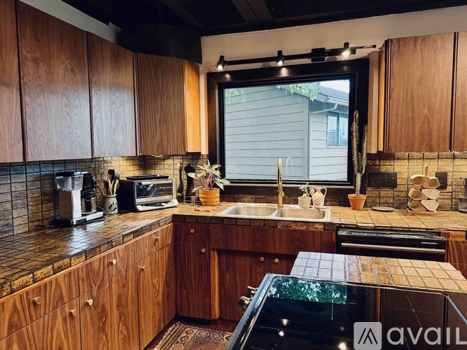 A kitchen with wooden cabinets and a black countertop.