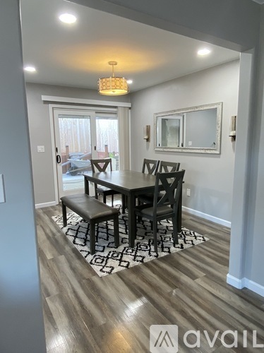 A dining room with a wooden table and chairs.