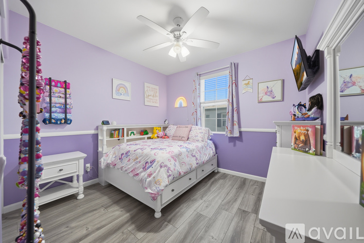 A bedroom with purple walls and a white bed.