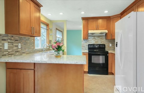 A kitchen with wooden cabinets and a white refrigerator.