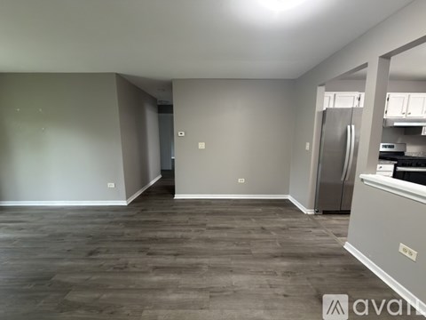 A spacious kitchen with a refrigerator and cabinets.