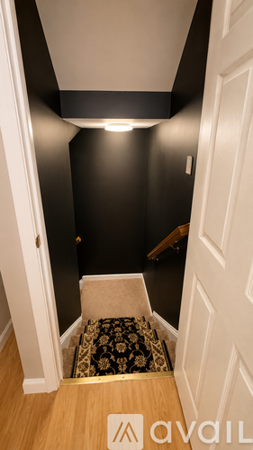 A hallway with a carpeted stairway leading to the second floor.