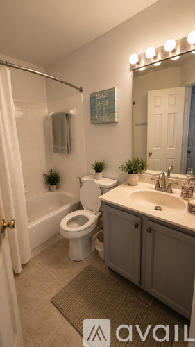 A bathroom with a toilet, sink, and mirror.