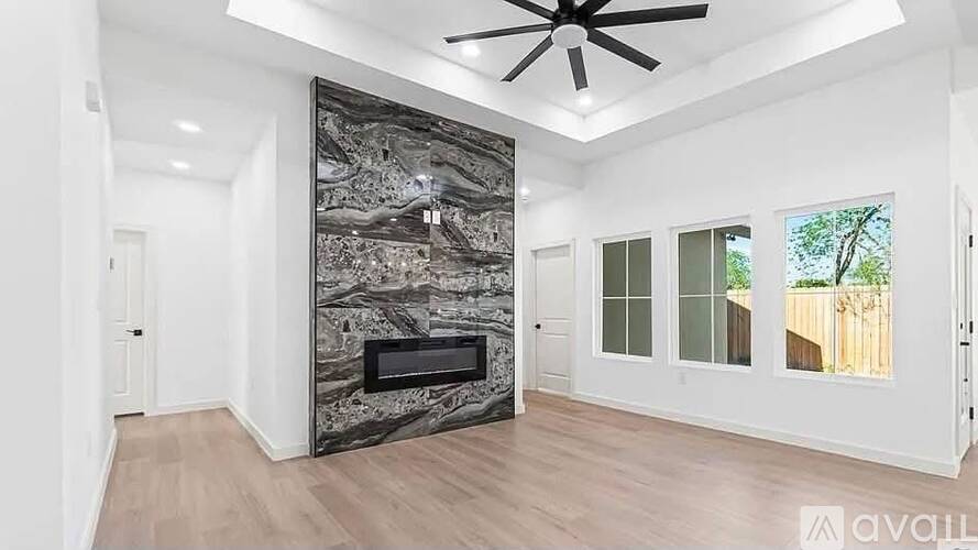 A modern living room with a fireplace and a ceiling fan.