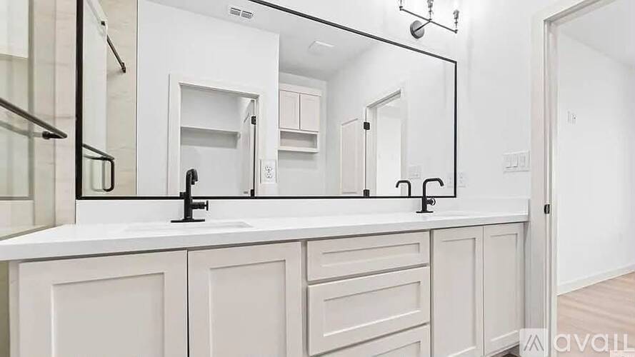 A bathroom with a white countertop and a large mirror above it.