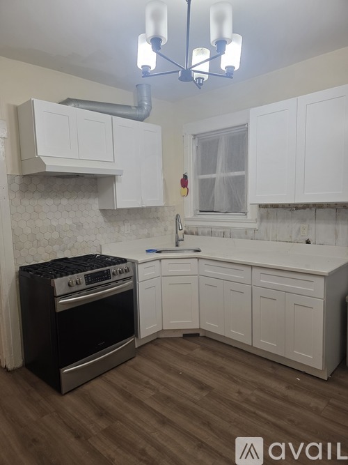 A kitchen with white cabinets and a black stove top oven.
