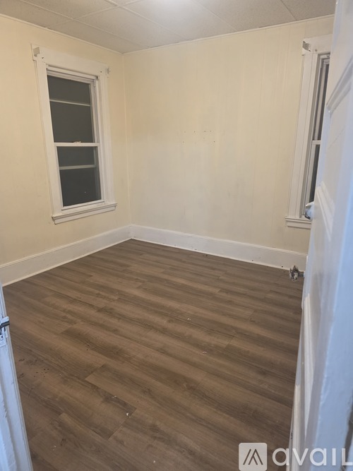 A room with wooden flooring and a window.