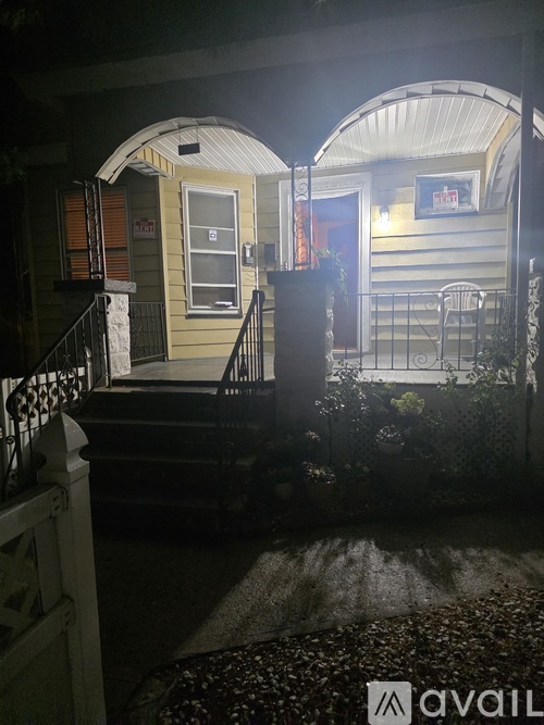 A house with a porch and a sign that says "AVAIL" on the front door.