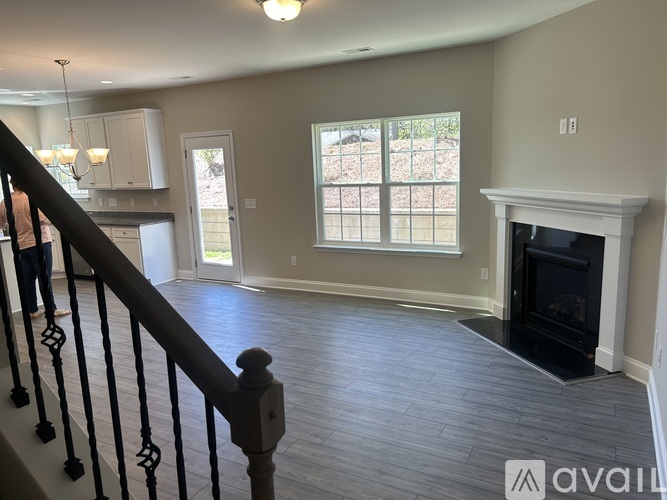 A living room with a fireplace and a staircase.
