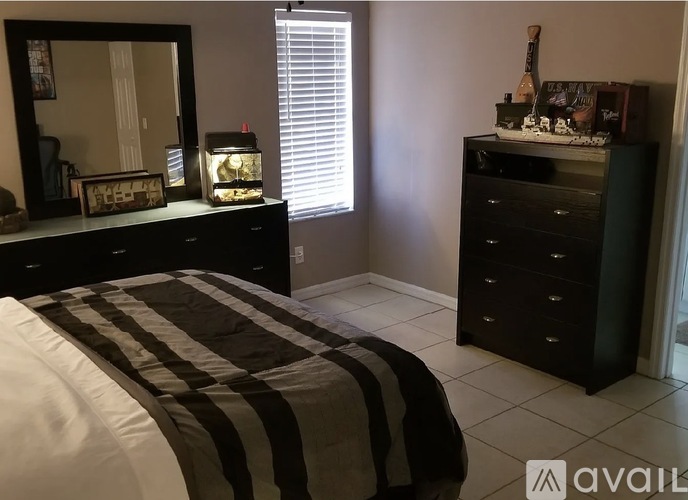 A bedroom with a bed, dresser, and mirror.
