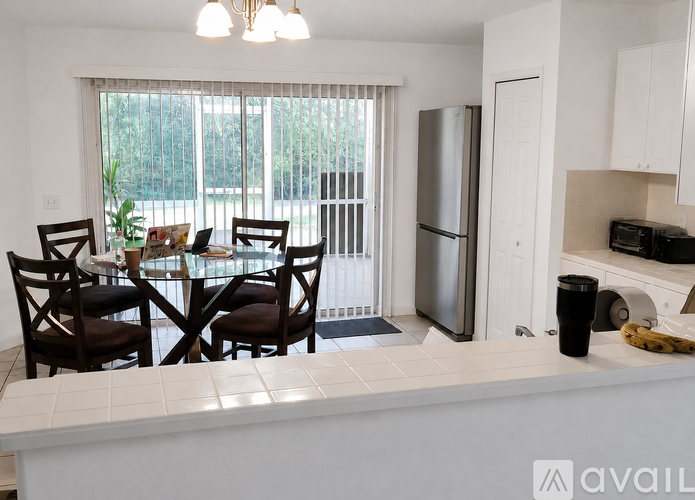A kitchen with a table and chairs by a window.