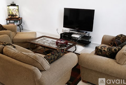 A living room with a large television and a coffee table.
