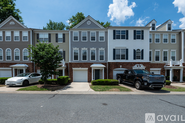 A row of townhouses with a black truck parked in front of the first one.