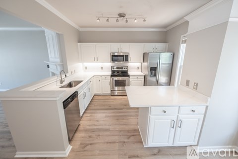 A kitchen with white cabinets and appliances.