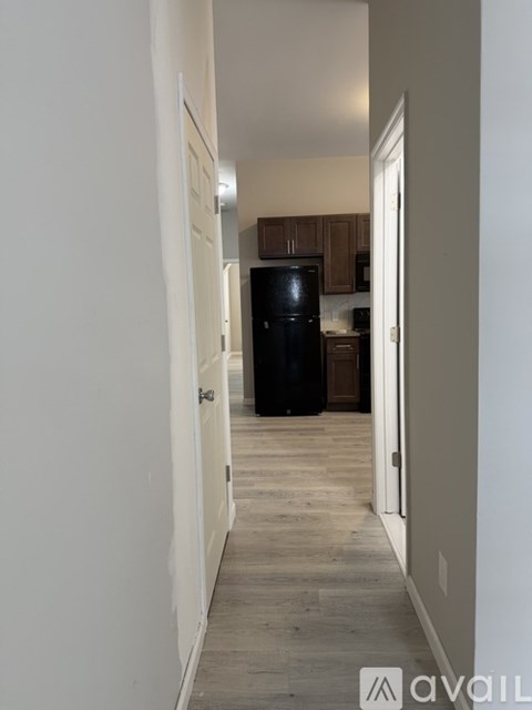 A black refrigerator in a kitchen with wooden cabinets.