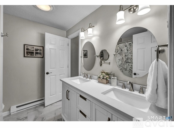 A bathroom with a white sink and a mirror above it.