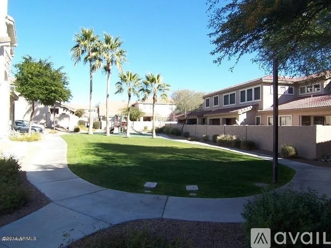 A sunny day in a neighborhood with houses and palm trees.