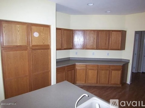 A kitchen with wooden cabinets and a white counter.