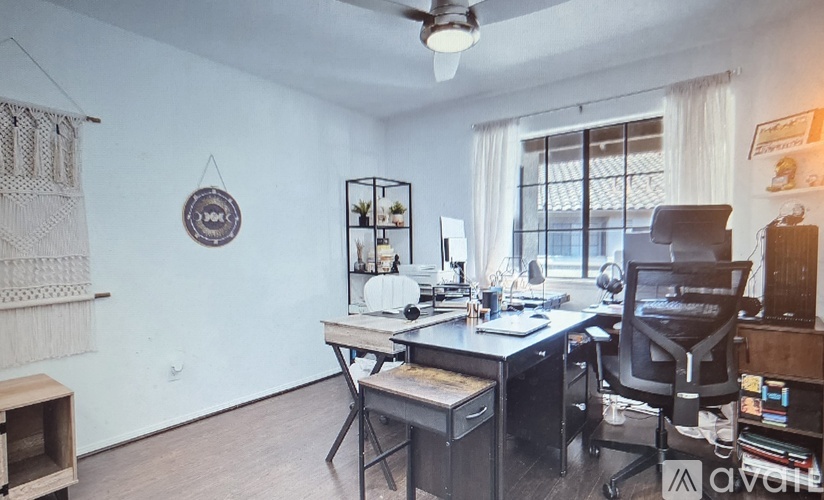 A home office with a desk, chair, and computer setup.