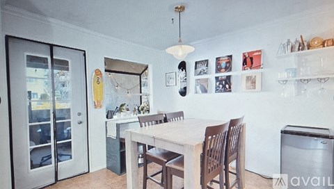 A kitchen with a table and chairs and a fridge.