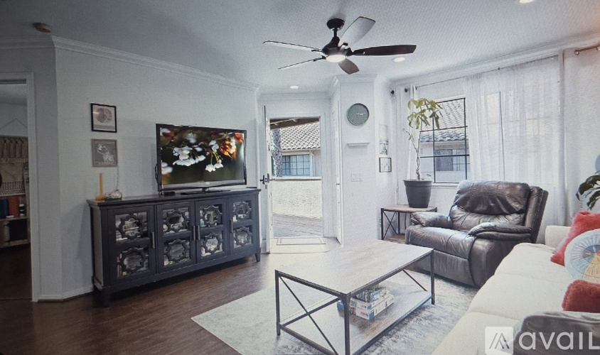 A living room with a television, a couch, and a coffee table.