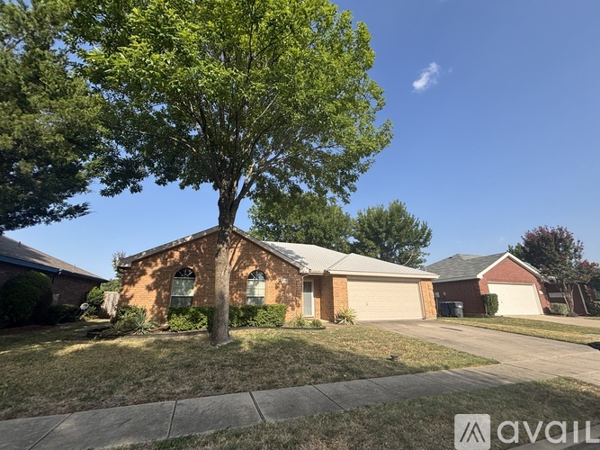 A tree stands in front of a brick house with a sign that says "AVAILABLE".