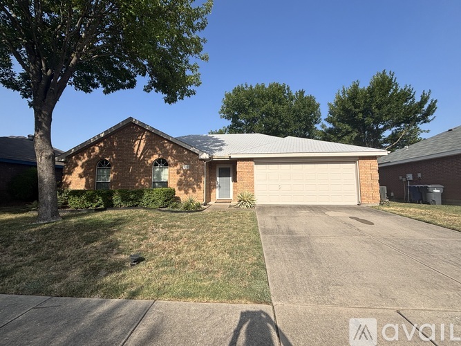 A house with a garage and a tree in front.