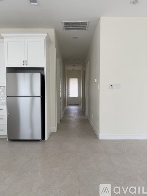 A kitchen with a refrigerator and cabinets.