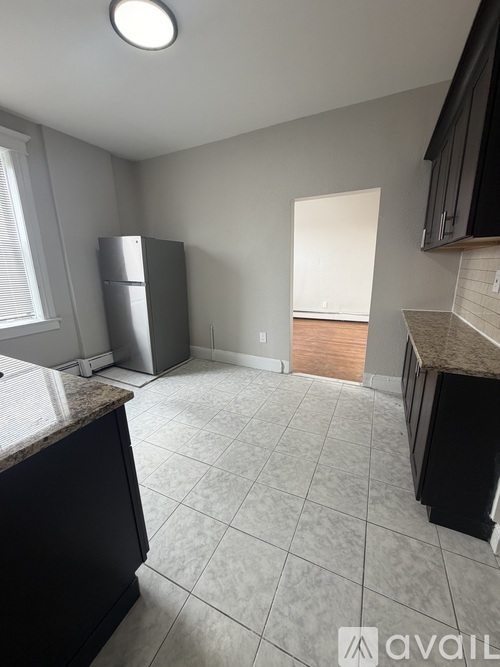 A kitchen with a marble countertop and a refrigerator.