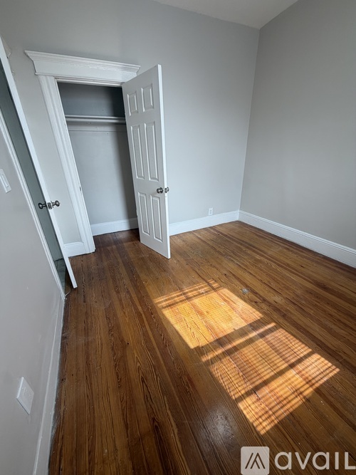 A room with a wooden floor and a white door.